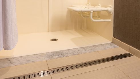 Low-threshold walk-in shower base with built-in seat