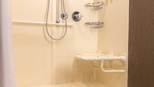 Accessible walk-in shower with fold-down seat and grab bars